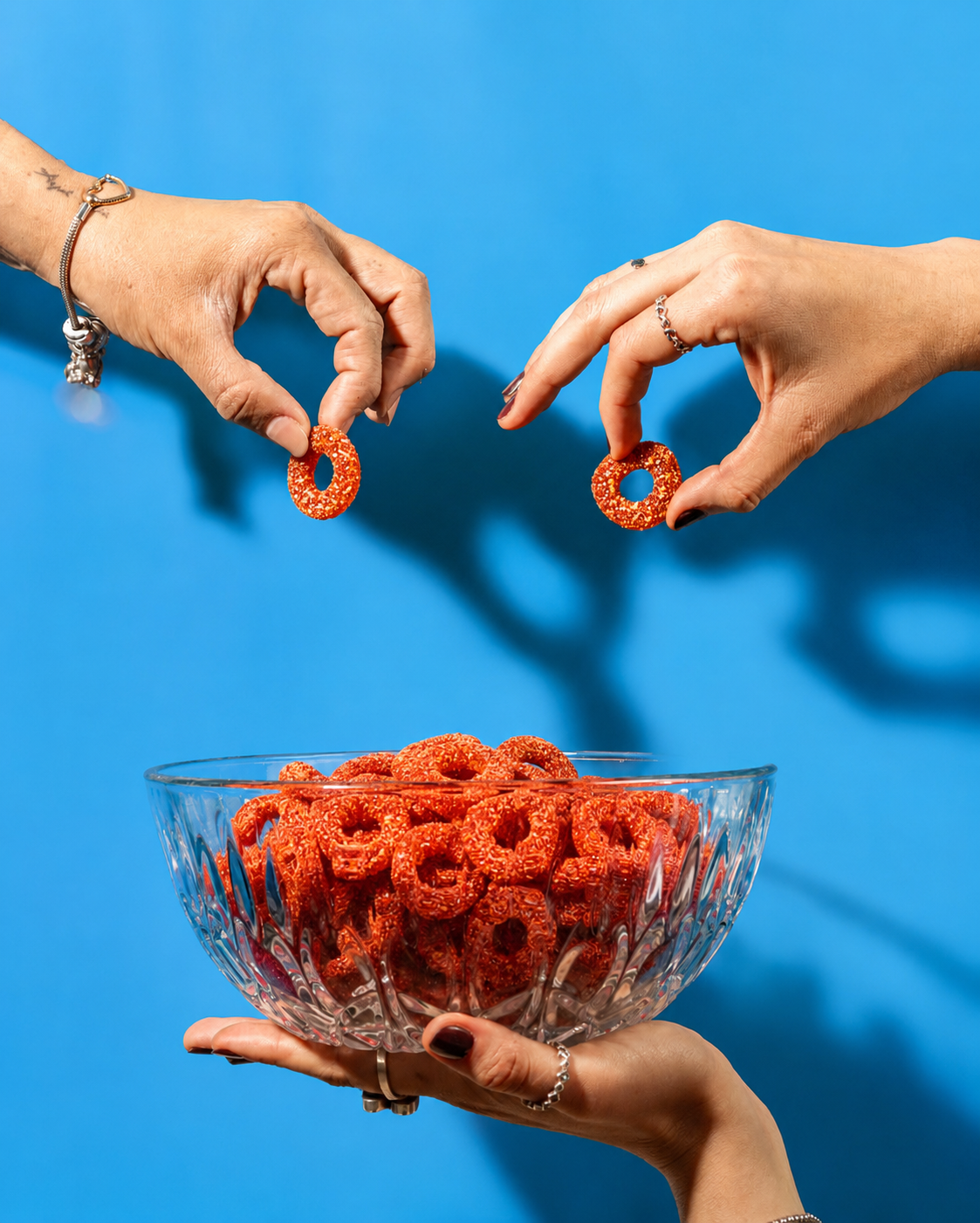 Hands holding a bowl of Candy Cult gummies